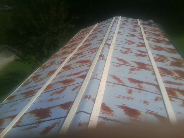 Rusted metal roof panels with new wood purlins before replacement — Storm Damage Roof Repair in Riverside by Roofing Brothers